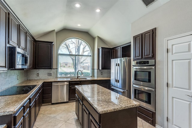 kitchen with visible vents, a sink, light tile patterned floors, vaulted ceiling, and stainless steel appliances