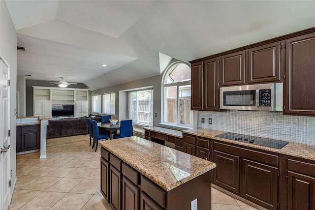 kitchen with a ceiling fan, black electric cooktop, stainless steel microwave, lofted ceiling, and light tile patterned flooring