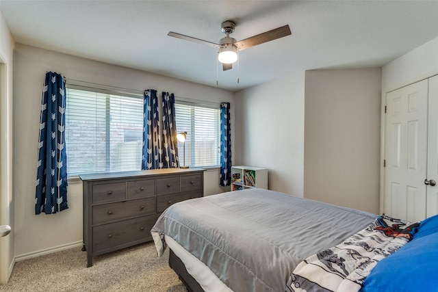 bedroom featuring baseboards, ceiling fan, and light colored carpet