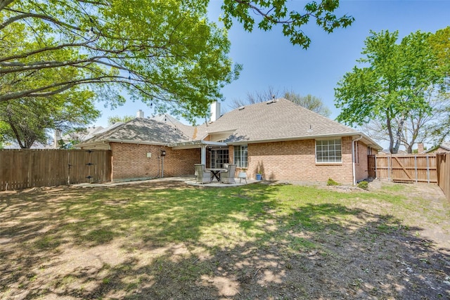 back of property with a chimney, a gate, a patio area, brick siding, and a fenced backyard