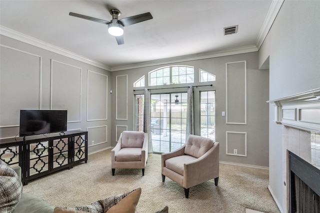 sitting room featuring visible vents, a ceiling fan, a decorative wall, and ornamental molding