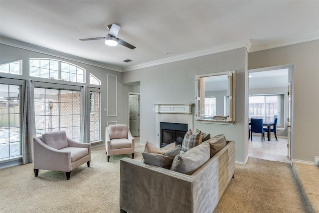 living room with visible vents, ornamental molding, a fireplace, light colored carpet, and a ceiling fan