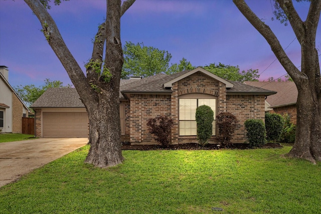 ranch-style home with brick siding, an attached garage, roof with shingles, and concrete driveway