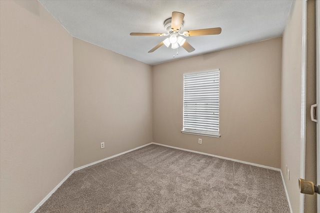 carpeted empty room featuring a ceiling fan and baseboards