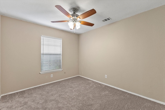 carpeted empty room featuring baseboards, ceiling fan, and visible vents