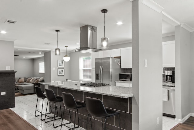 kitchen featuring visible vents, marble finish floor, island range hood, white cabinetry, and stainless steel appliances