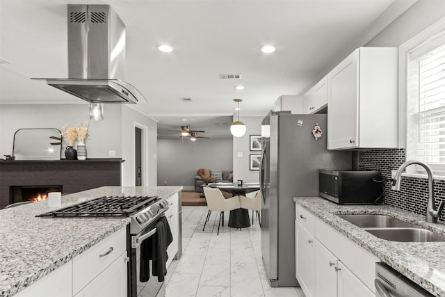 kitchen featuring visible vents, open floor plan, island exhaust hood, a sink, and stainless steel appliances