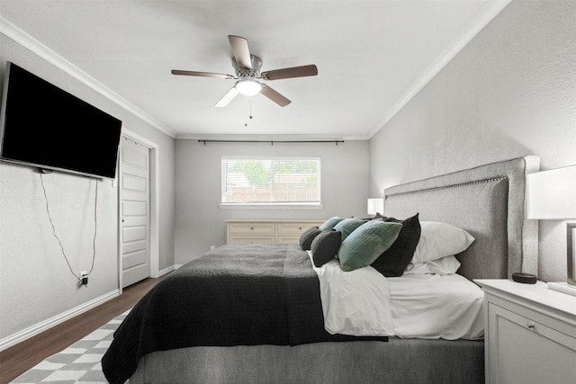bedroom featuring baseboards, ceiling fan, ornamental molding, and wood finished floors