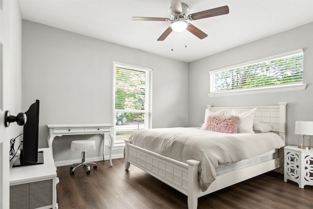 bedroom with a ceiling fan, baseboards, and dark wood-type flooring