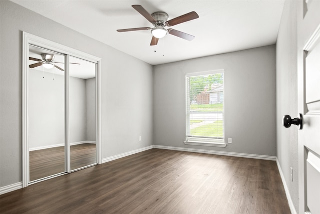 unfurnished bedroom with baseboards, dark wood finished floors, and ceiling fan