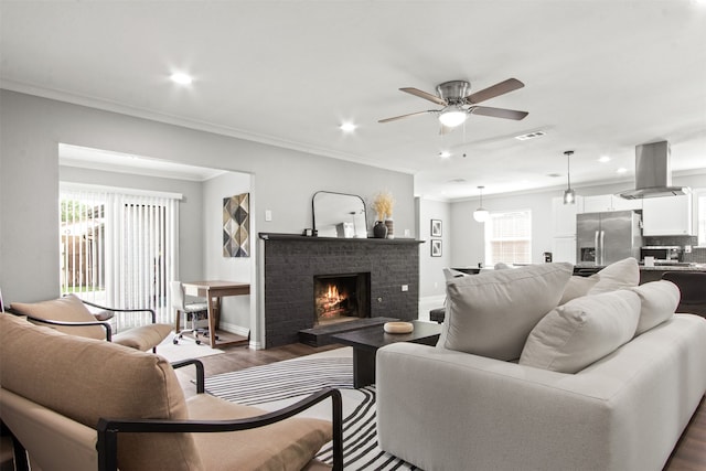 living area featuring recessed lighting, ornamental molding, dark wood finished floors, and a ceiling fan