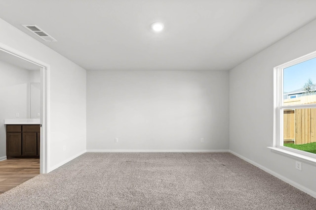 spare room featuring baseboards, carpet flooring, and visible vents