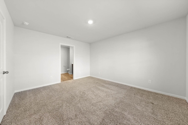 spare room with light colored carpet, recessed lighting, baseboards, and visible vents