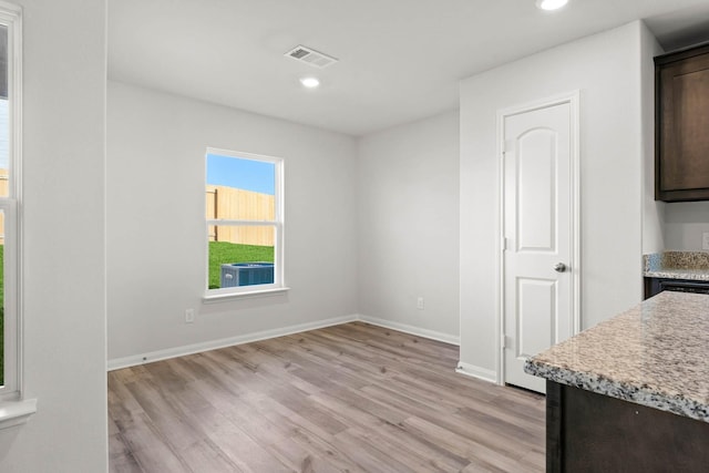 unfurnished dining area featuring recessed lighting, baseboards, light wood-type flooring, and visible vents