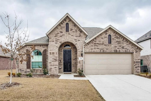 2704 Dancing Flame Dr, Denton, TX 76201 - french country style house featuring brick siding, concrete driveway, a shingled roof, a garage, and a front yard