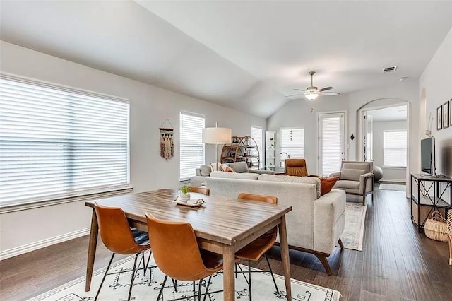 2704 Dancing Flame Dr, Denton, TX 76201 - dining area featuring a ceiling fan, arched walkways, dark wood-type flooring, baseboards, and vaulted ceiling
