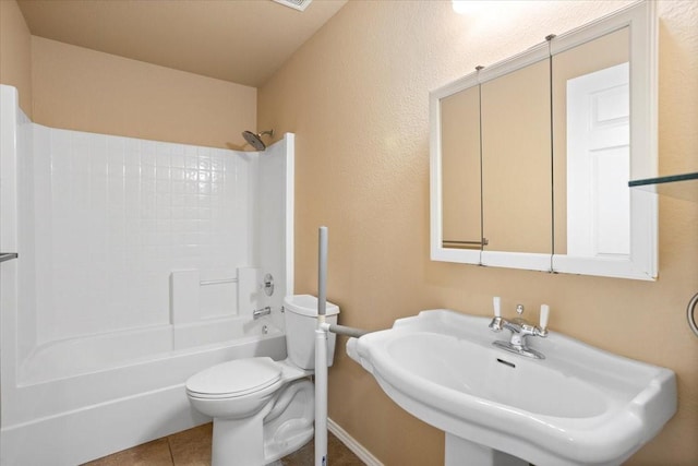 full bath with a sink, toilet, bathtub / shower combination, tile patterned flooring, and baseboards