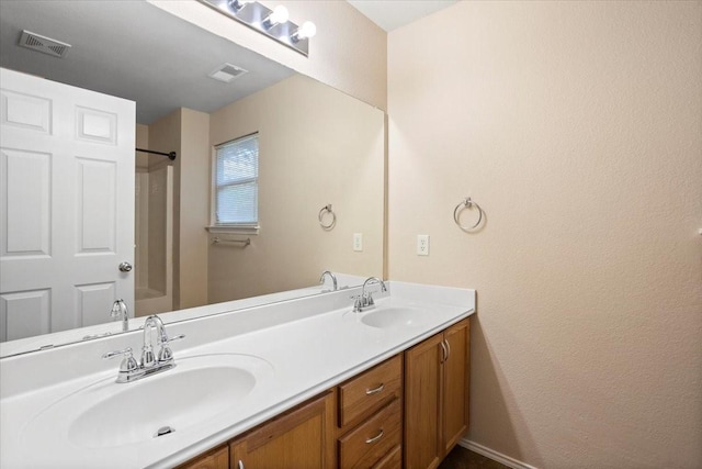 full bathroom featuring double vanity and a shower