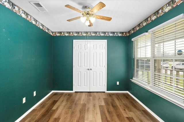 unfurnished bedroom with baseboards, a closet, and wood finished floors