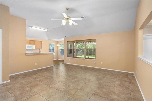 unfurnished living room featuring a ceiling fan, vaulted ceiling, and baseboards