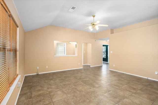 empty room featuring ceiling fan, vaulted ceiling, and baseboards