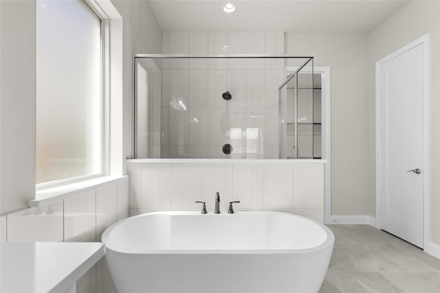 4524 Sky Harbor Dr, Rockwall, TX 75087 - full bathroom featuring baseboards, marble finish floor, a freestanding bath, and a stall shower