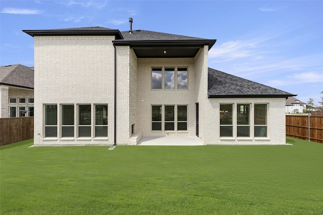 4524 Sky Harbor Dr, Rockwall, TX 75087 - rear view of property with roof with shingles, brick siding, a fenced backyard, a lawn, and a patio