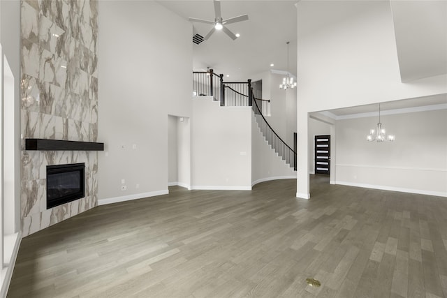 4524 Sky Harbor Dr, Rockwall, TX 75087 - unfurnished living room featuring wood finished floors, stairs, a tile fireplace, and a towering ceiling