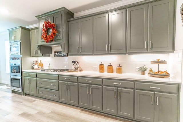 bar with decorative backsplash, stainless steel appliances, and light wood-style flooring