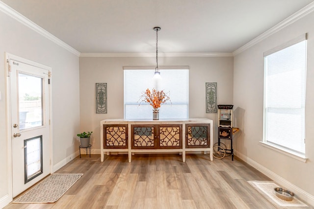 dining space featuring baseboards, ornamental molding, and light wood-type flooring