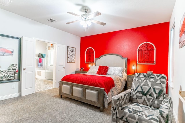 carpeted bedroom featuring baseboards, ceiling fan, ensuite bath, and visible vents