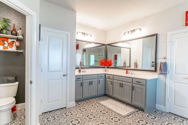 bathroom with a sink, tile patterned flooring, toilet, and double vanity