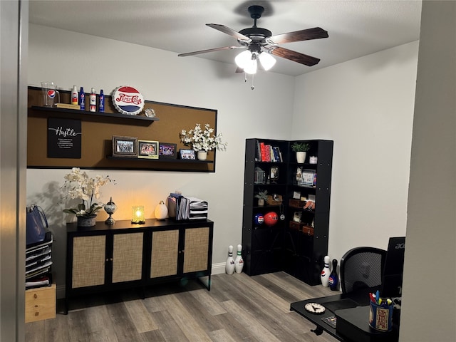office space featuring baseboards, ceiling fan, and wood finished floors