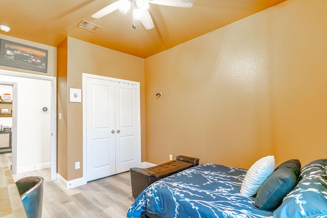 bedroom with light wood-style floors, a ceiling fan, baseboards, visible vents, and a closet