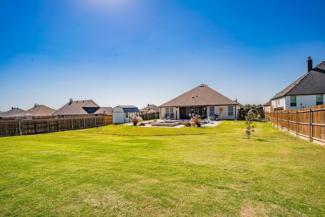 view of yard featuring a residential view, a storage shed, a fenced backyard, an outbuilding, and a patio