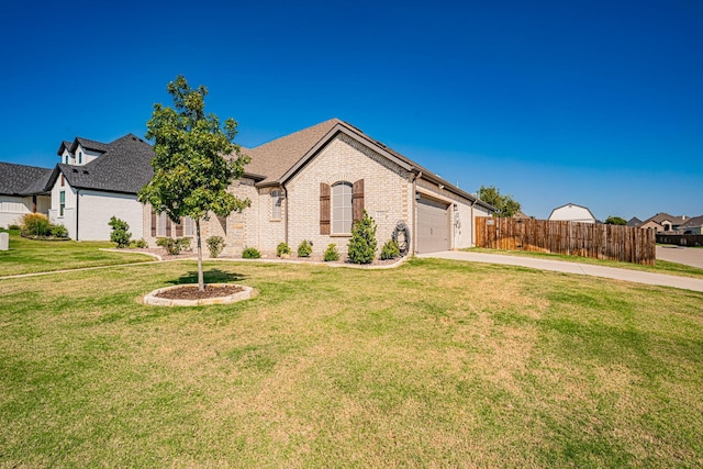 view of front facade featuring fence, an attached garage, a front lawn, brick siding, and driveway