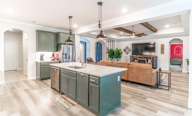 kitchen with a sink, arched walkways, ceiling fan, and stainless steel appliances