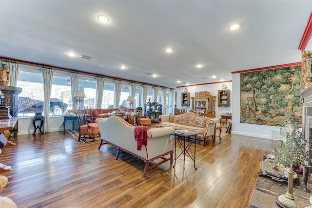 living area featuring crown molding, recessed lighting, baseboards, wood finished floors, and visible vents