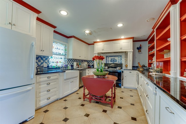 kitchen with freestanding refrigerator, black range with electric cooktop, backsplash, and ornamental molding