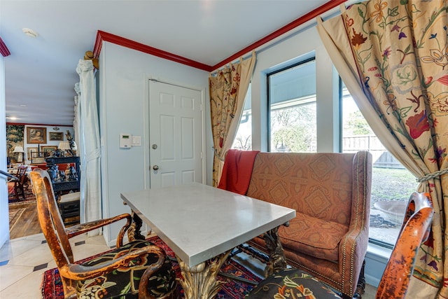 dining area featuring ornamental molding and light tile patterned flooring