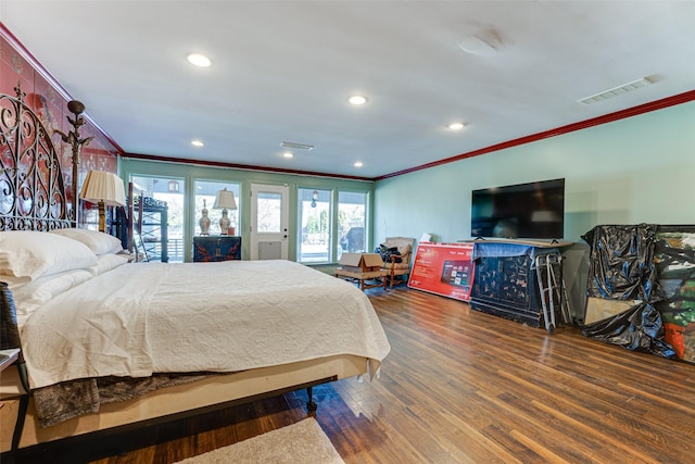 bedroom with crown molding, recessed lighting, wood finished floors, and visible vents