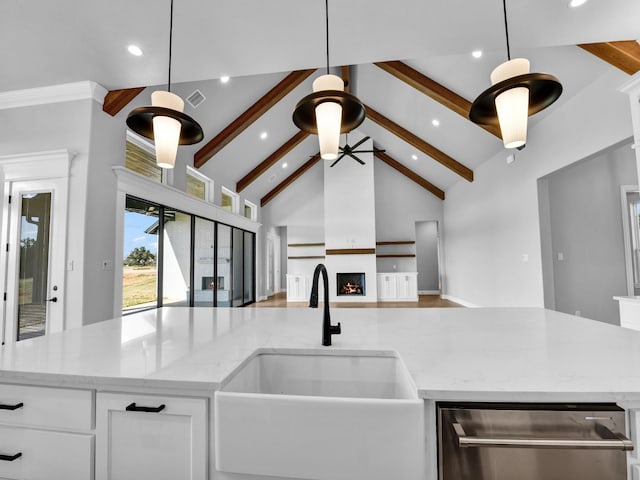 kitchen featuring a kitchen island with sink, beamed ceiling, open floor plan, high vaulted ceiling, and a sink