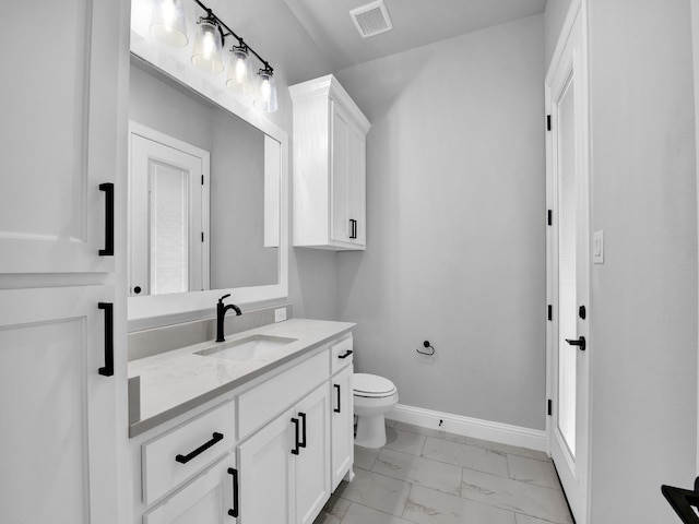 bathroom featuring vanity, toilet, marble finish floor, baseboards, and visible vents