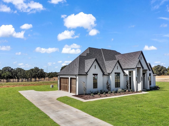 view of front facade with a garage, a front lawn, roof with shingles, and concrete driveway