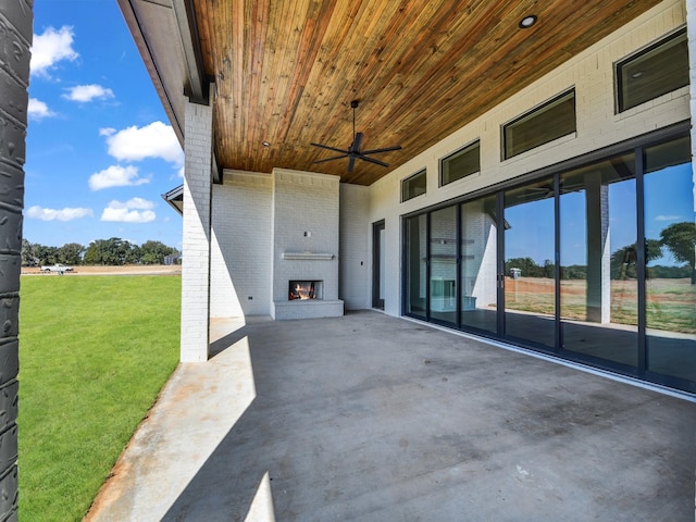 view of patio featuring a ceiling fan and an outdoor brick fireplace