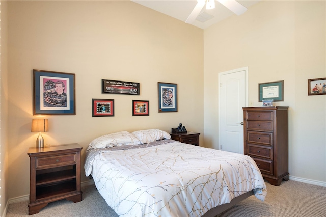 bedroom with carpet floors, baseboards, and a high ceiling