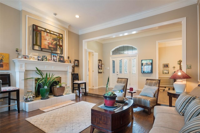 living room featuring ornamental molding, baseboards, dark wood-type flooring, recessed lighting, and a tile fireplace