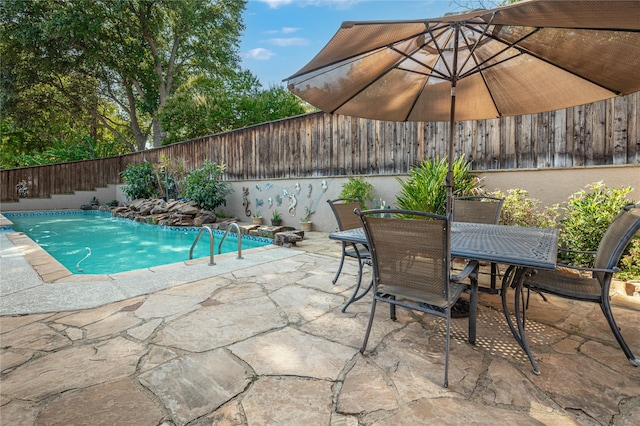 view of swimming pool with a fenced in pool, a fenced backyard, a patio area, and outdoor dining space