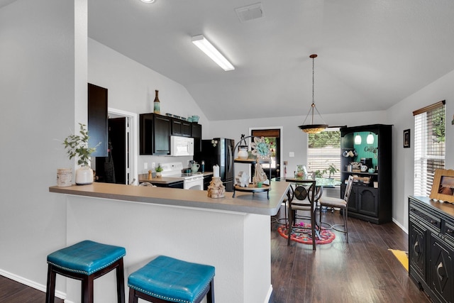 kitchen with white appliances, a breakfast bar area, light countertops, dark wood finished floors, and lofted ceiling