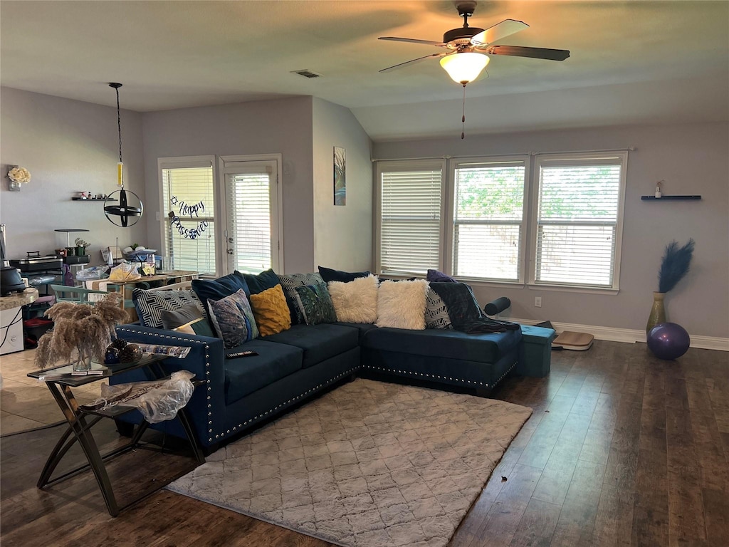 living area with wood-type flooring, a ceiling fan, baseboards, and vaulted ceiling
